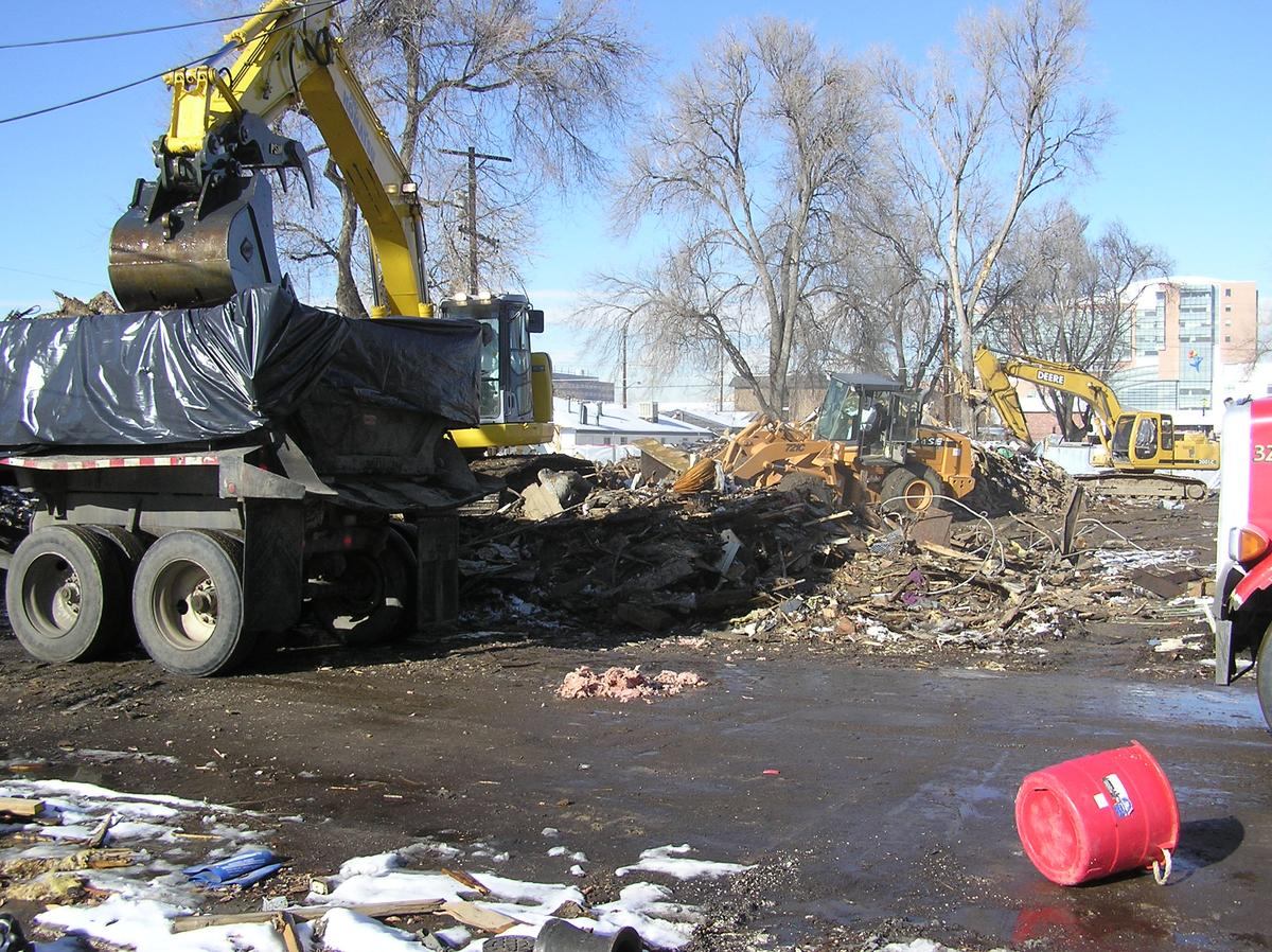 Excavators loading covered trailers on a contained site