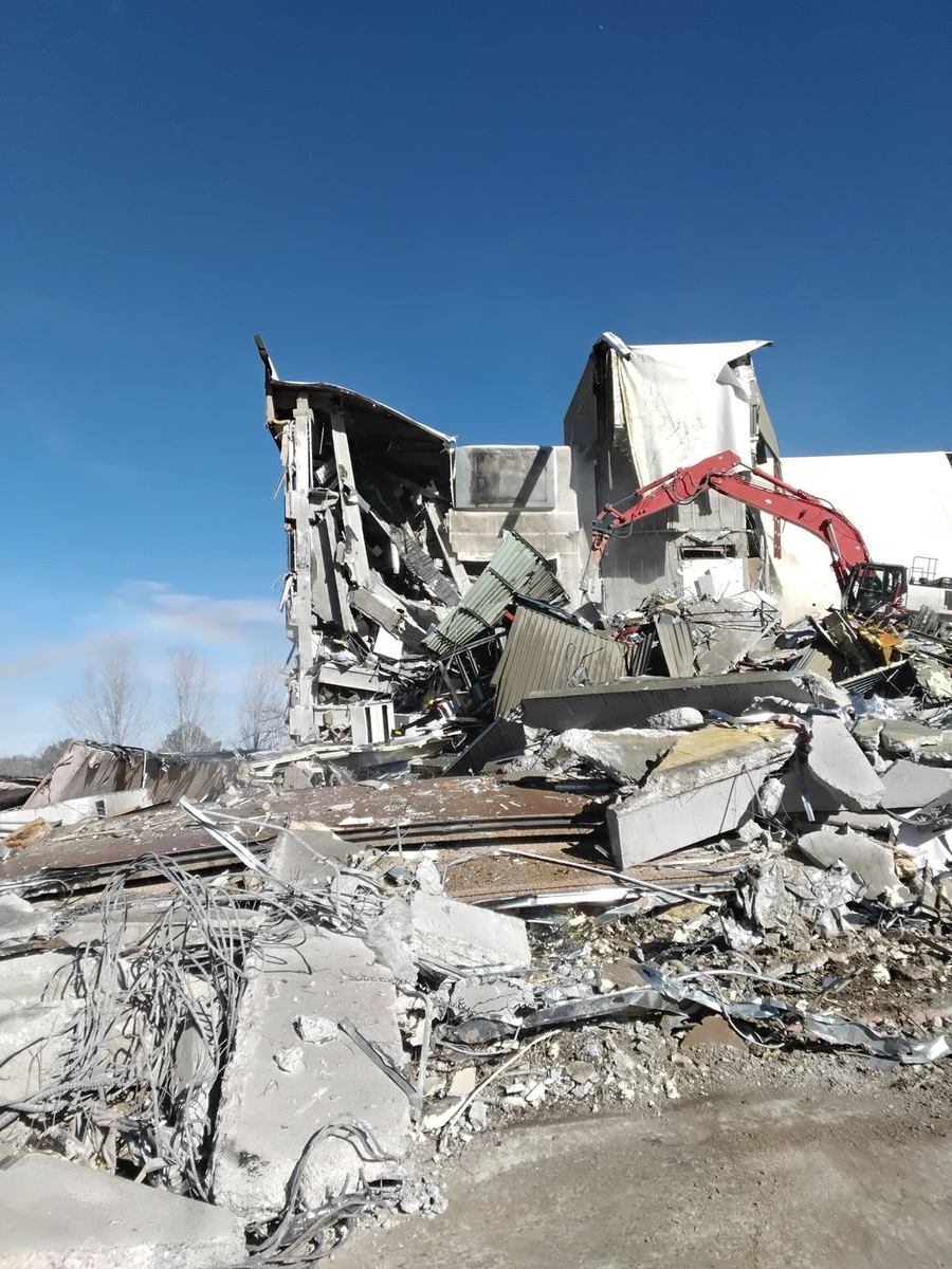 Altitude excavator performing commercial structural demolition