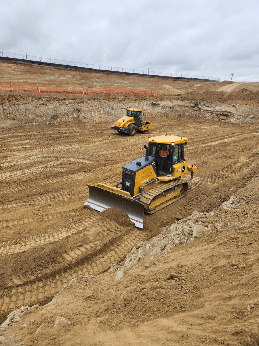 Altitude dozer grading and roller compacting in a mass excavation