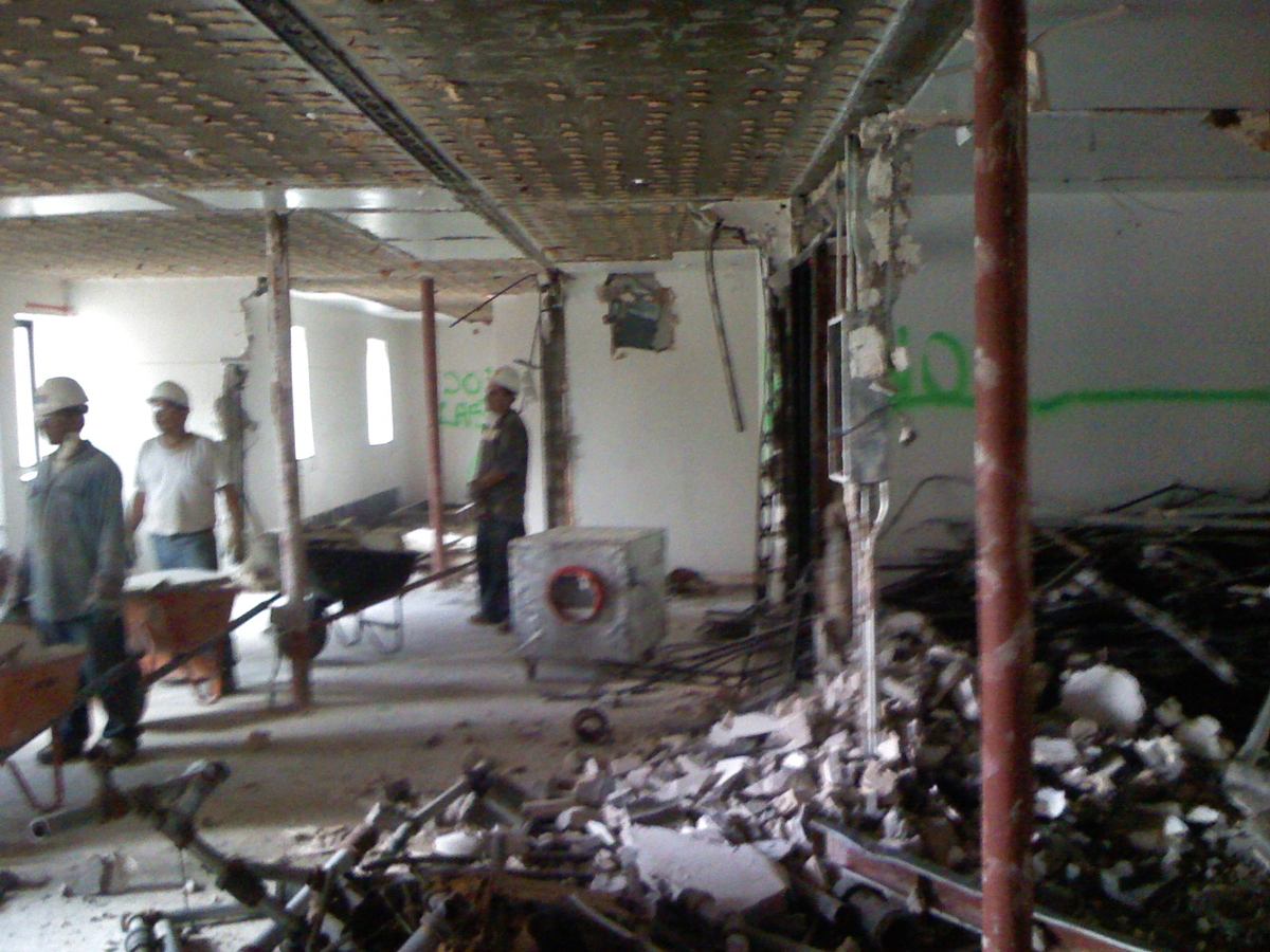 Crew hauling out demolition debris by wheelbarrow