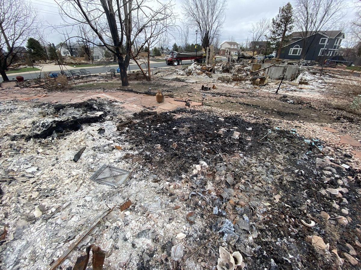 Altitude skid steer working a fire-damaged foundation