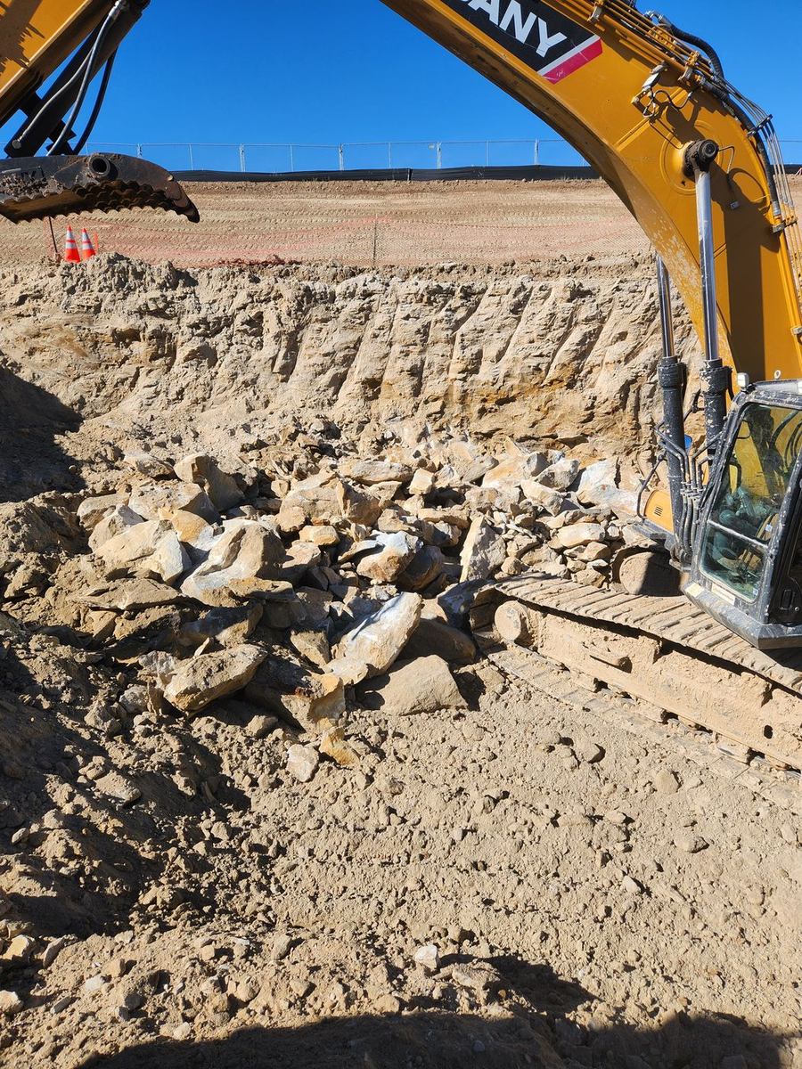 Hydraulic hoe-ram working a rock face