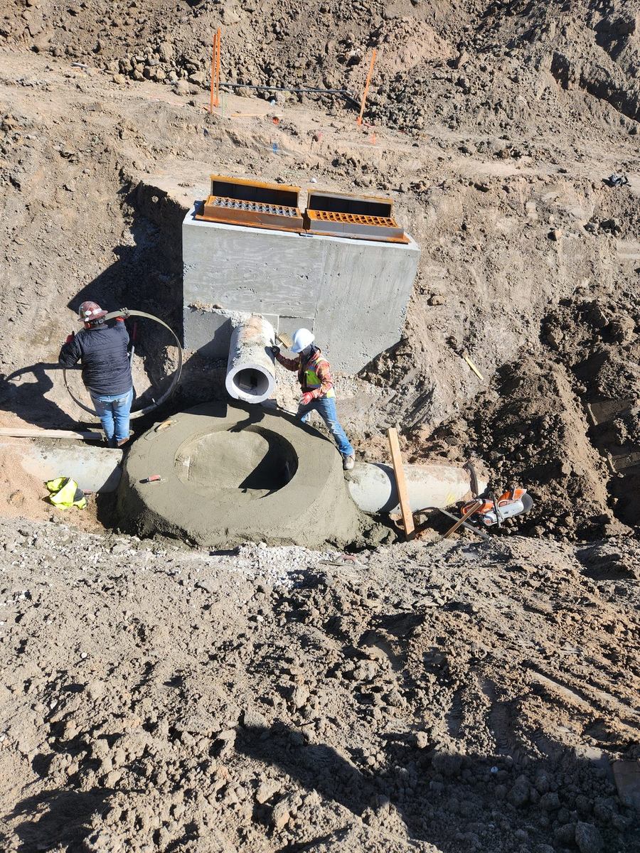 Crew finishing concrete on a cast-in-place storm structure