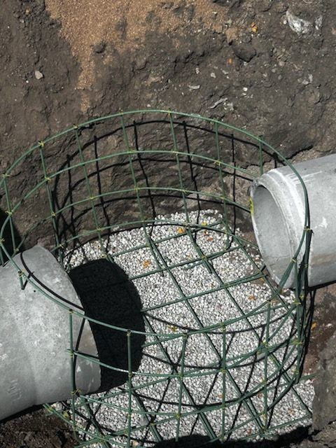 Rebar cage set around pipe on a gravel base for a cast-in-place structure